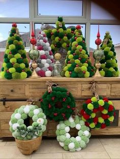 christmas wreaths are displayed in front of a window