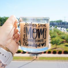 a person holding up a coffee mug with the words, fearless strong mom on it