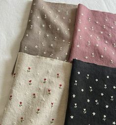 four different colors of fabric with small flowers on them, all lined up in rows