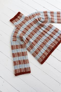 a red and white checkered scarf laying on top of a wooden floor