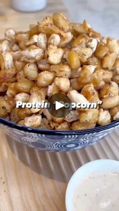 a bowl filled with nuts sitting on top of a wooden table