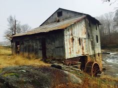 an old wooden building sitting next to a river