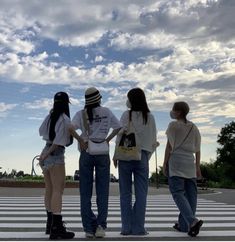 four people standing in the middle of a cross walk