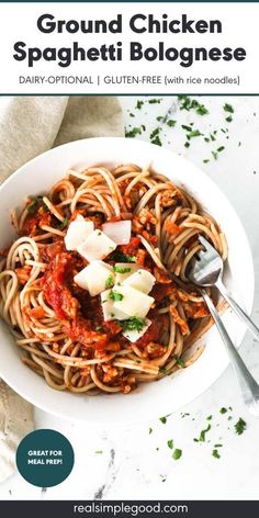 a white bowl filled with spaghetti and topped with parmesan cheese