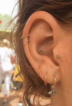 a close up of a person's ear with three different types of piercings