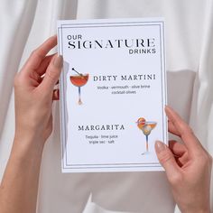 two hands holding up a drink menu for a party or cocktail bar with drinks on it