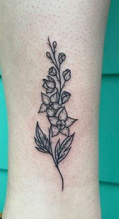 a black and white flower tattoo on the side of a woman's lower leg