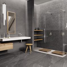 a modern bathroom with grey walls and flooring, including a walk - in shower