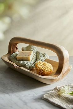 a wooden tray with soap and two pieces of bread in it on a marble table