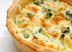 a quiche with broccoli and cheese is shown on a white tablecloth