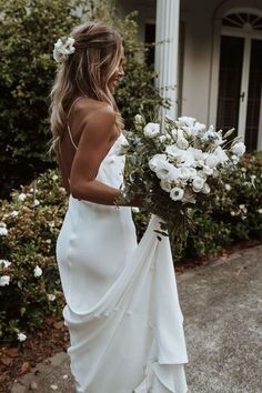 a woman in a white dress holding flowers