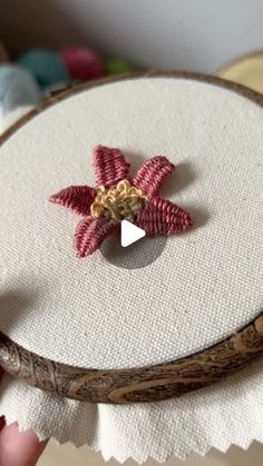 a close up of a person holding a piece of fabric with a flower on it