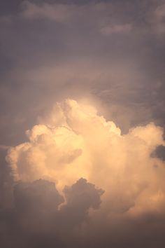 an airplane is flying in the cloudy sky