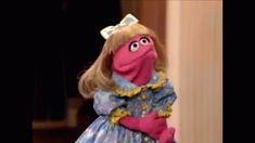 the muppet from sesame street is dressed in a blue dress with yellow trims