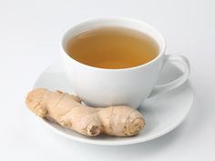 there is a cup of tea and a ginger on the saucer