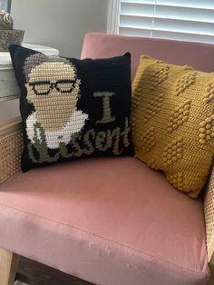 a pink chair with two knitted pillows on it and a pillow that says i love nelson