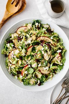 a white bowl filled with salad next to silverware