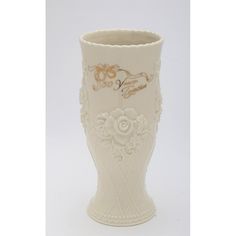 a white vase with gold trimmings and flowers on the side, sitting in front of a white background