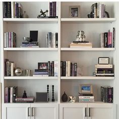 a white book shelf filled with lots of books and knick - knacks