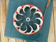 an overhead view of a red and white wheel on a green table with a wooden spoon