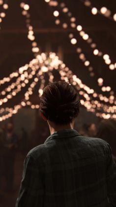 a woman standing in front of a chandelier with many lights hanging from it