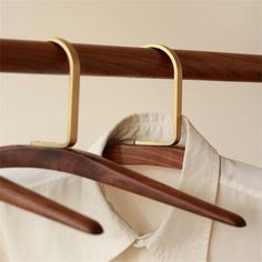 two wooden hangers are attached to a white shirt