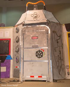 a large metal structure with various electrical equipment on it's sides and an orange cord hanging from the ceiling