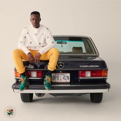 a man sitting on the back of a black mercedes benz w160 coupe car