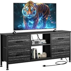 an entertainment center with a television on top of it and a tiger painting on the screen