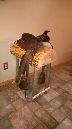 a horse saddle sitting on top of a wooden bench with a ribbon tied around it