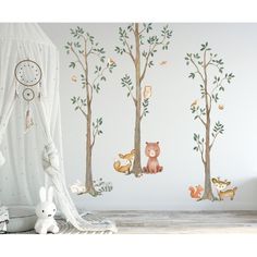 a child's room with wall decals and animals on the trees, including a teddy bear