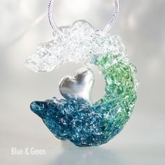 The ocean wave blown glass pendant with sterling silver 925 heart is perfect for ocean inspired style. The great wave mermaidcore jewelry is a waterproof necklace from blown glass. The heady glass pendant is an unique holiday gift idea for surfers, scuba diver, mermaids, sea and ocean lovers.  Size: 1.2″x1.2″ = 30×30 mm Materials: glass, sterling silver 925, hypoallergenic steel (a chain) All ocean vibe jewelry are handcrafted by me in my studio in Aveiro, Portugal. Please note that all jewelry in the DriftLand Shop is handmade TO ORDER, ensuring each piece is unique and may vary slightly from the images shown. Your ocean inspired style beachy jewelry will be one-of-a-kind, capturing the essence of the sample in color, style, and overall aesthetic. I craft using American, Italian, Czech, a Ocean-inspired Silver Glass Jewelry, Ocean-inspired Silver Glass Necklace, Ocean-inspired Glass Necklaces For Gifts, Beachy Jewelry, Gifts For Surfers, Heady Glass, Blown Glass Pendant, Unique Holiday Gifts, Ocean Inspired