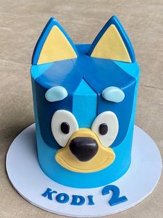 a blue cake with an animal face on it's side and the number 2