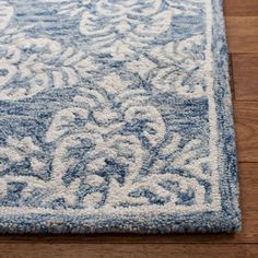 a blue and white area rug on a wooden floor with a wood floor in the background