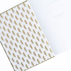 an open book with gold leaf designs on the cover and white paper in the middle