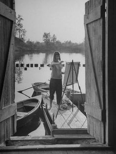 a woman standing at the end of a boat dock