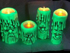 three green candles with faces painted on them