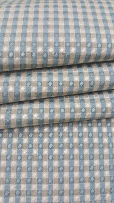 the blue and white checkered fabric is folded on top of each other with polka dots