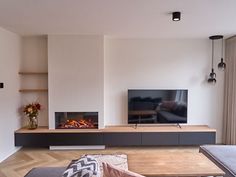 a living room with a couch, fireplace and television on the wall in front of it