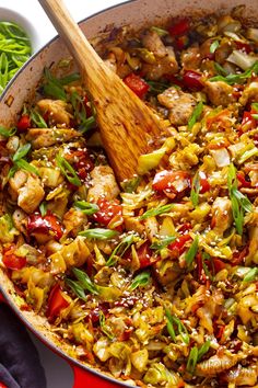 a skillet filled with chicken and vegetables on top of a red cloth next to green beans