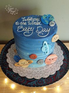 there is a blue cake that says i welcome to the world baby day on it