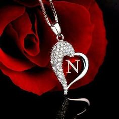 a red rose with the letter n on it and a diamond heart in the middle