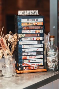 a stack of cds sitting on top of a counter next to a bottle and vase