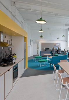 an office with chairs, desks and tables in the middle of the floor area