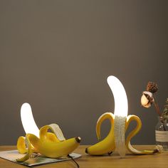 two banana shaped lights sitting on top of a wooden table