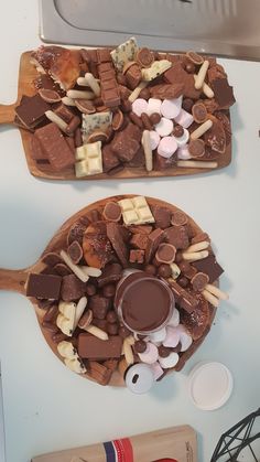 two trays filled with chocolate and marshmallows on top of a counter