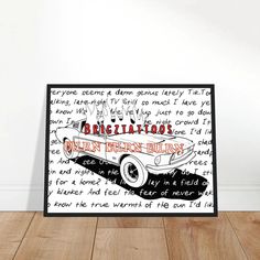 a black and white poster with words written on it in front of a wooden floor