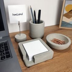 a desk with a laptop, pen holder and other office supplies