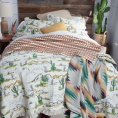 the bed is made up with colorful blankets and cactus decorations on it's headboard