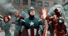 the avengers are standing in front of an old building with fire coming out of it